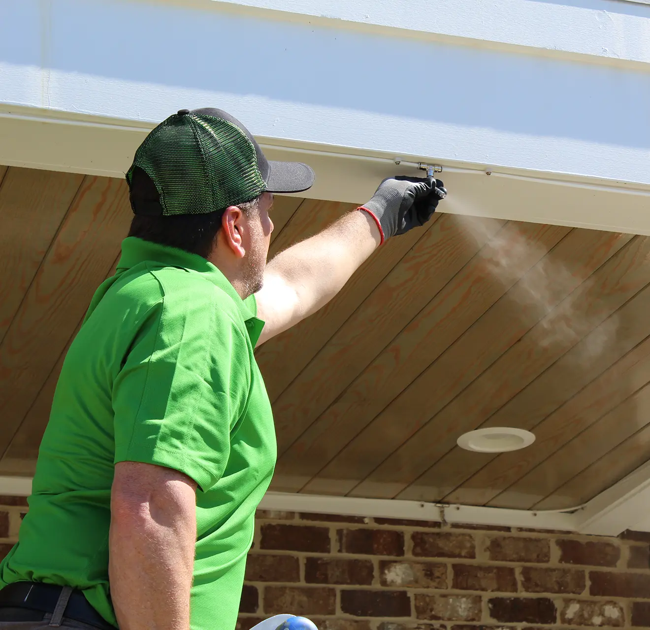 Mosquito Joe technician installing a mosquito misting system on a house.
