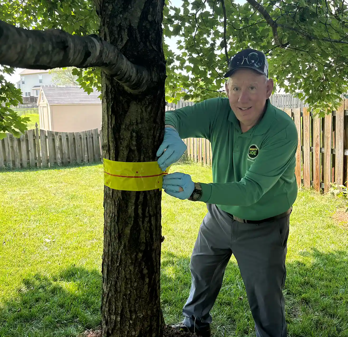 Mosquito Joe professional measuring a tree trunk.