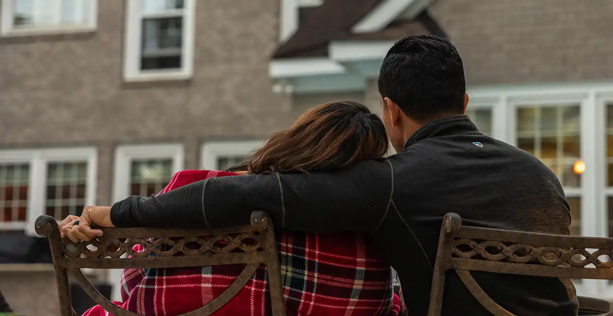 A couple cuddling outside and enjoying the view.